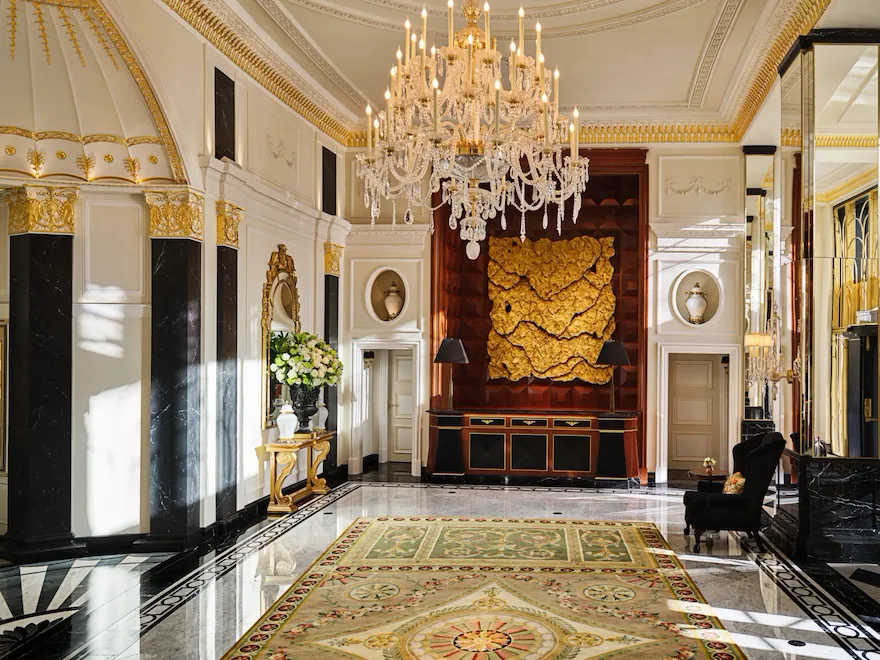 The Dorchester Lobby with reception desk and concierge desk in afternoon sunlight