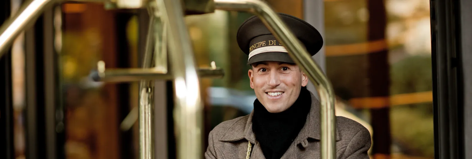 Portiere sorridente che spinge il carrello dei bagagli