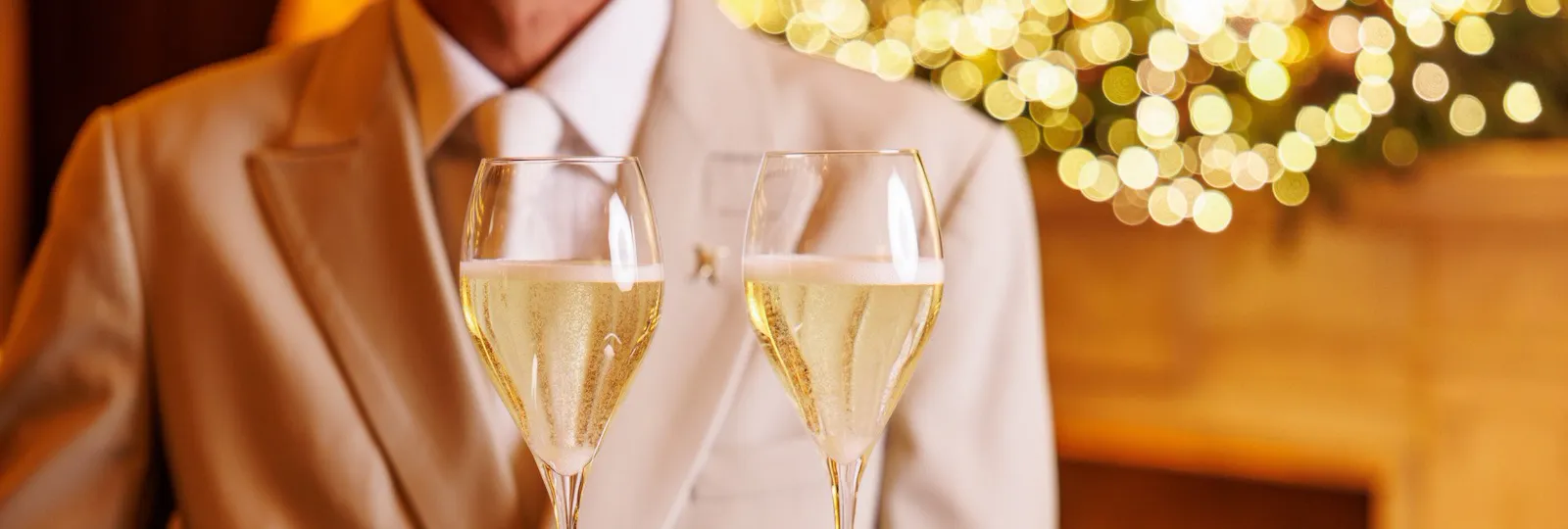 Cameriere con vassoi con 2 bicchieri di champagne a La Libreria, Hotel Eden