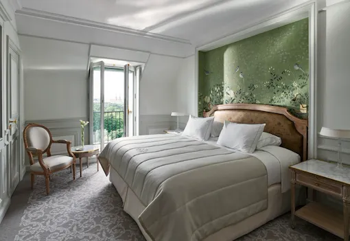 Côté chambre de la chambre supérieure, avec un mur peint à la main vert et la vue sur le jardin des Tuileries au loin. Au Meurice, Paris.