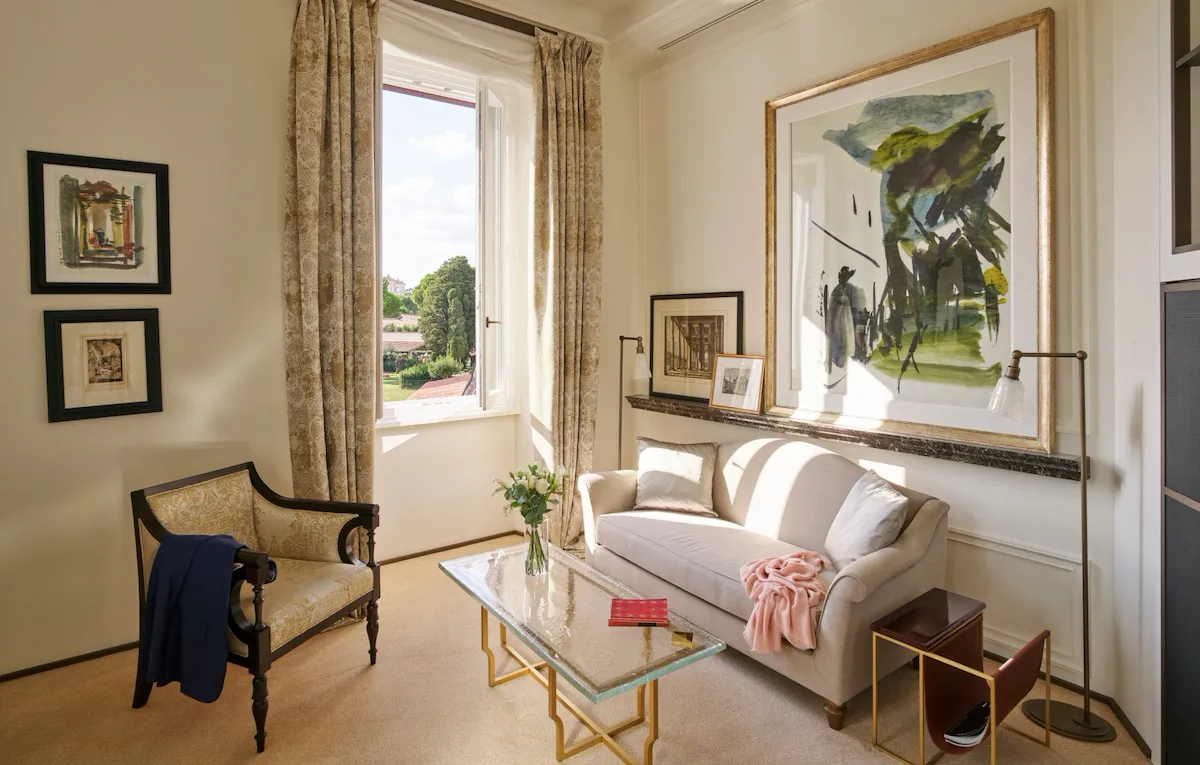 Living room with couch, armchair, paintings and coffee table at Classic Suite with view at Hotel Eden, Rome