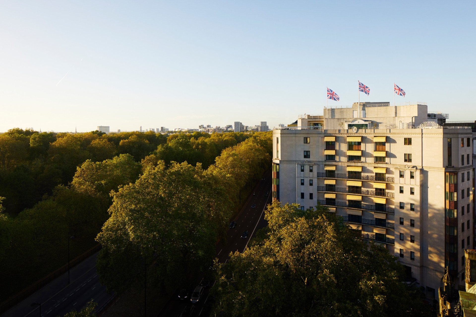 The Dorchester building exterior at sunset next to Hyde Park, London