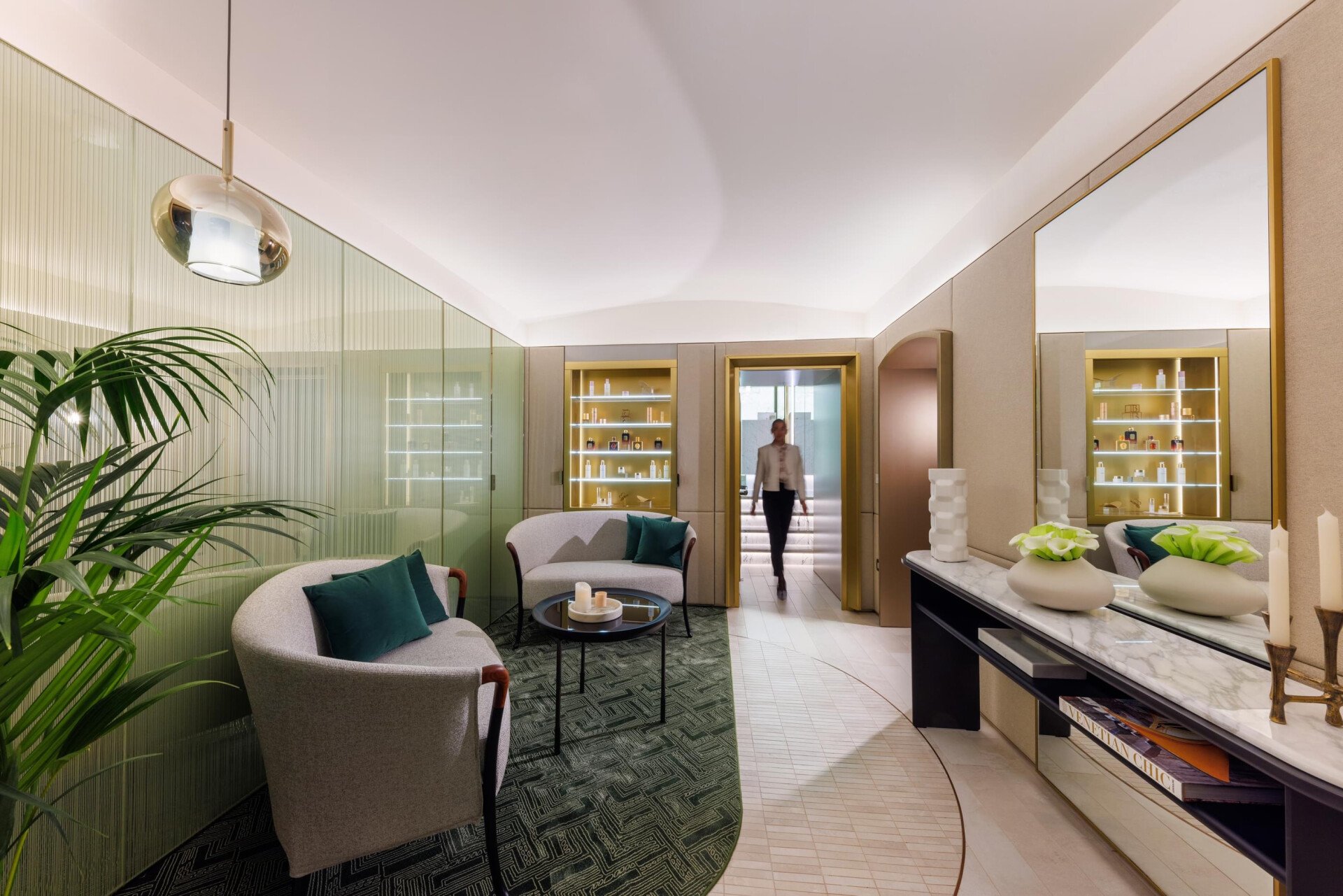 The relaxing area of our renovated The Eden Spa, featuring the Spa Manager walking towards one of the private treatment cabins.