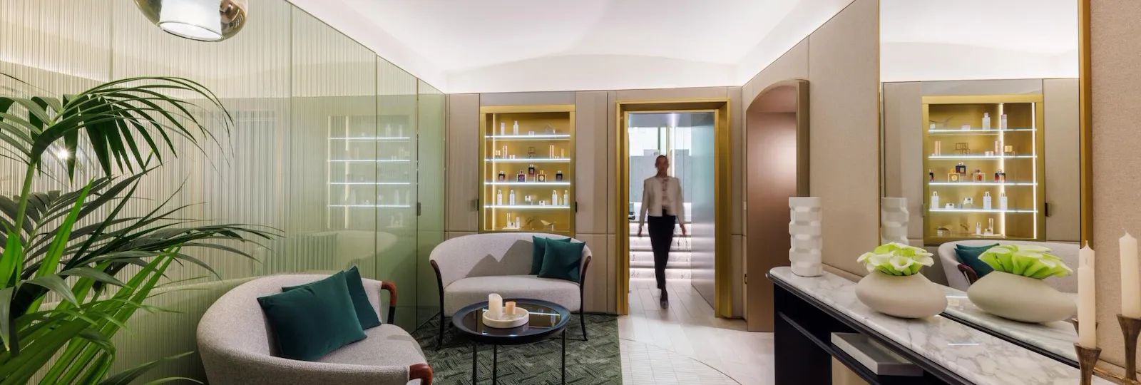 The relaxing area of our renovated The Eden Spa, featuring the Spa Manager walking towards one of the private treatment cabins.