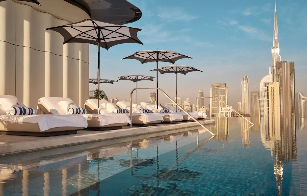 The Lana rooftop pool with sunlongers and view of Downtown Dubai