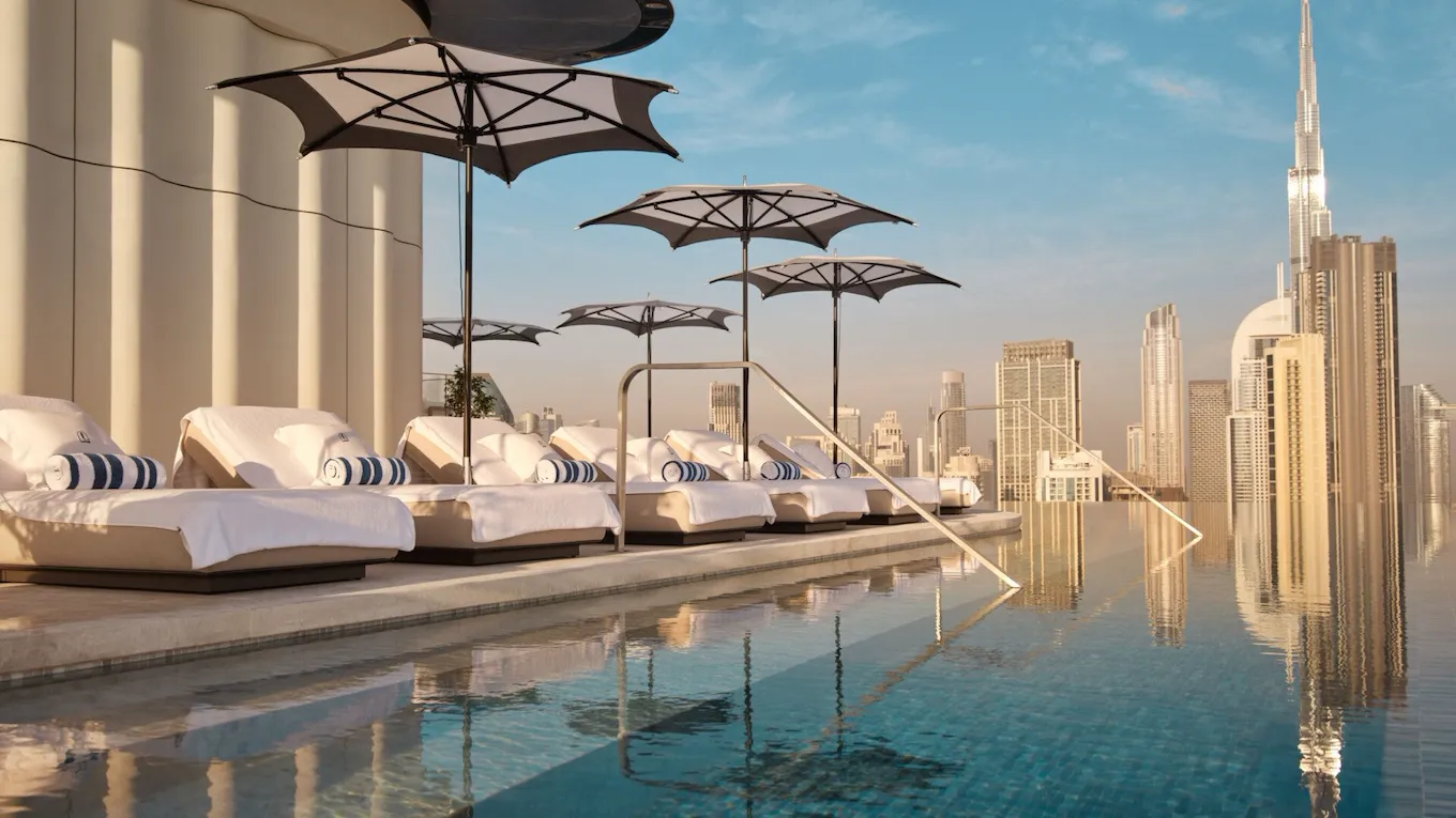 The Lana rooftop pool with sunlongers and view of Downtown Dubai