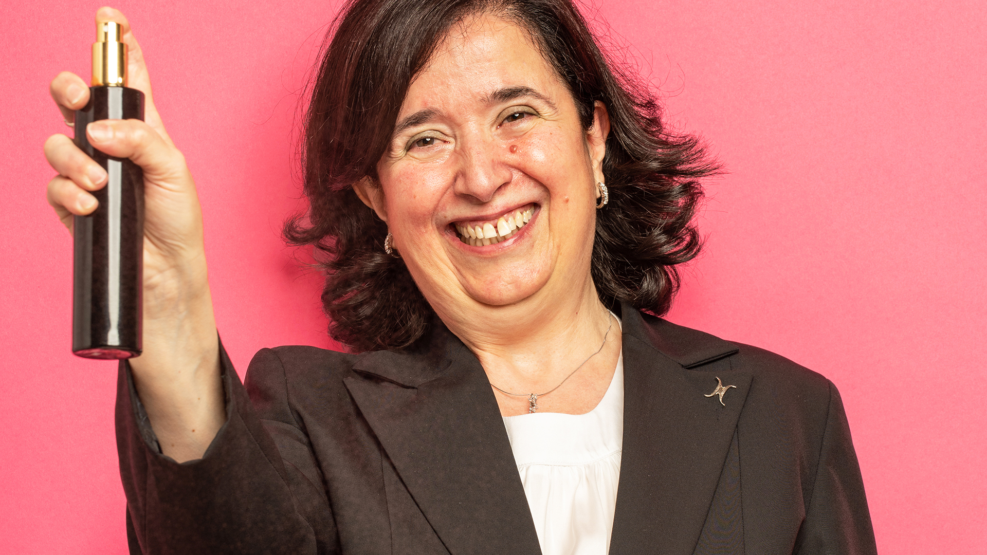 A smily woman holding body spray