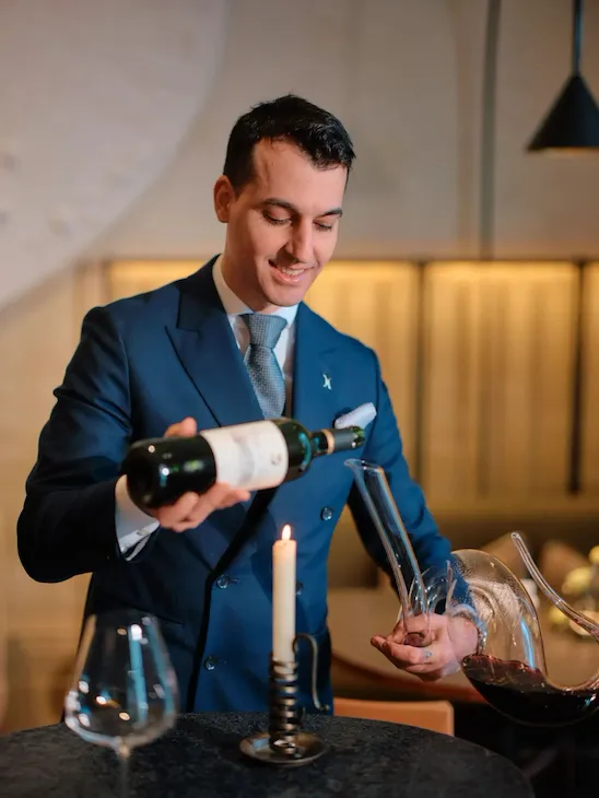 Sommelier holding wine bottle in Woven by Adam Smith restaurant
