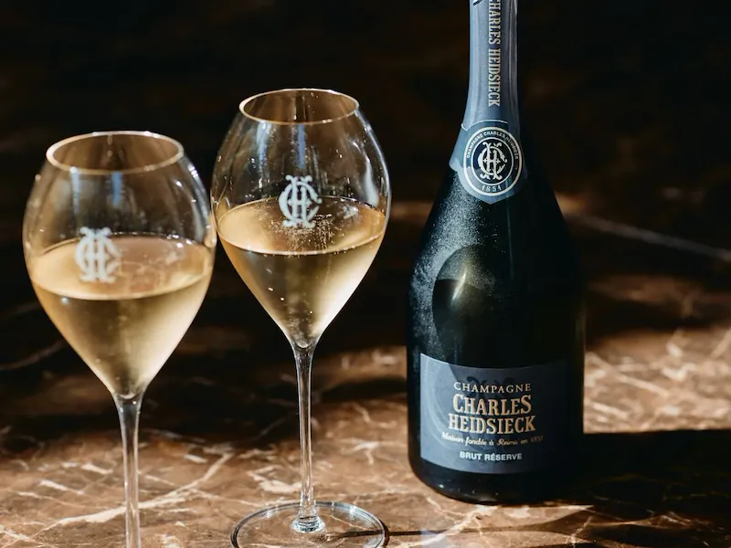 A close up to a Charles Heidsieck Brut Reserve bottle with two full glasses