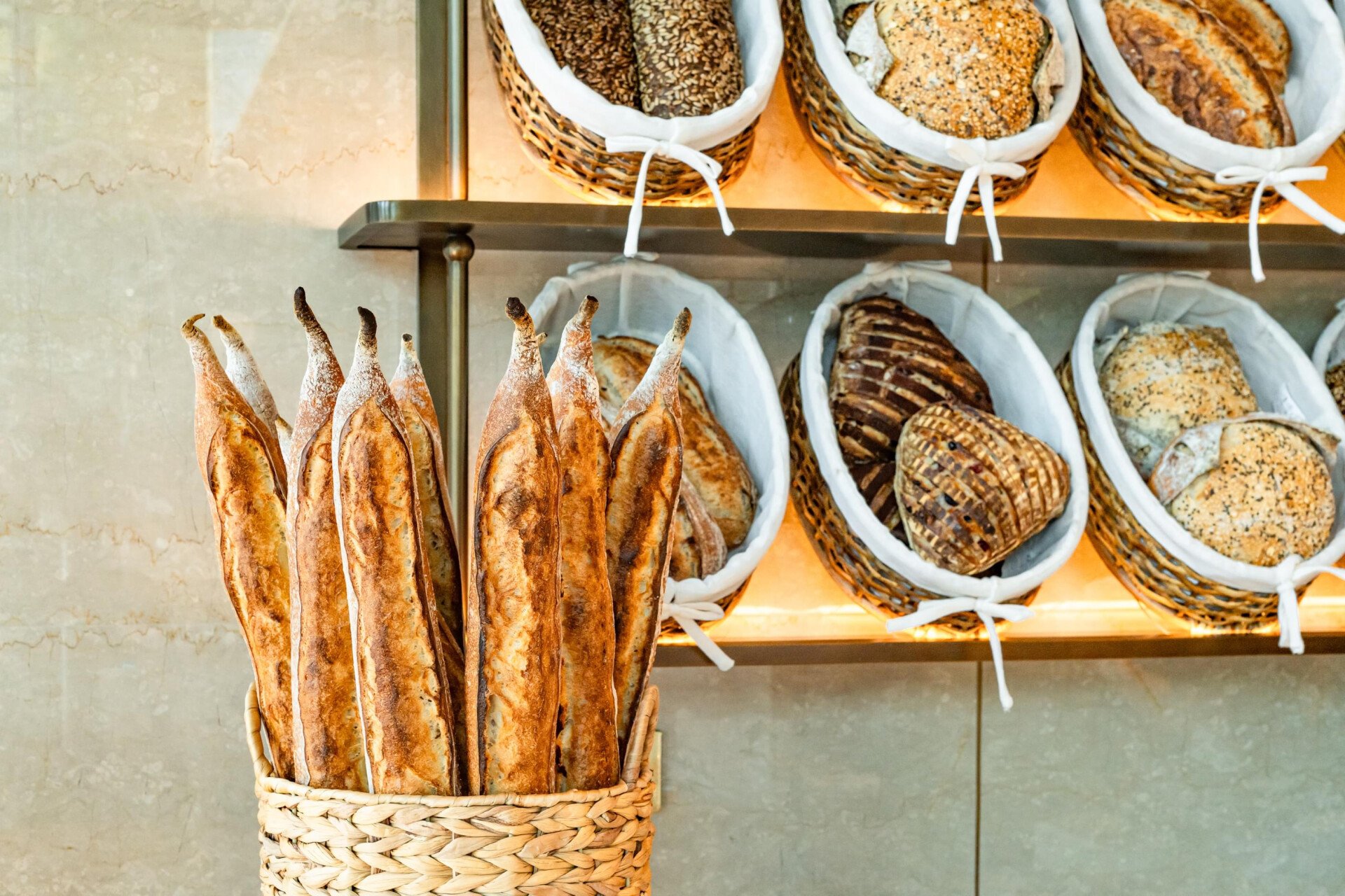 Landscape images of the variety of food and beverage offerings offered at Bonbon Café Angelo Musa, The Lana, Dubai, including chocolates, jams, pastries and bread. 