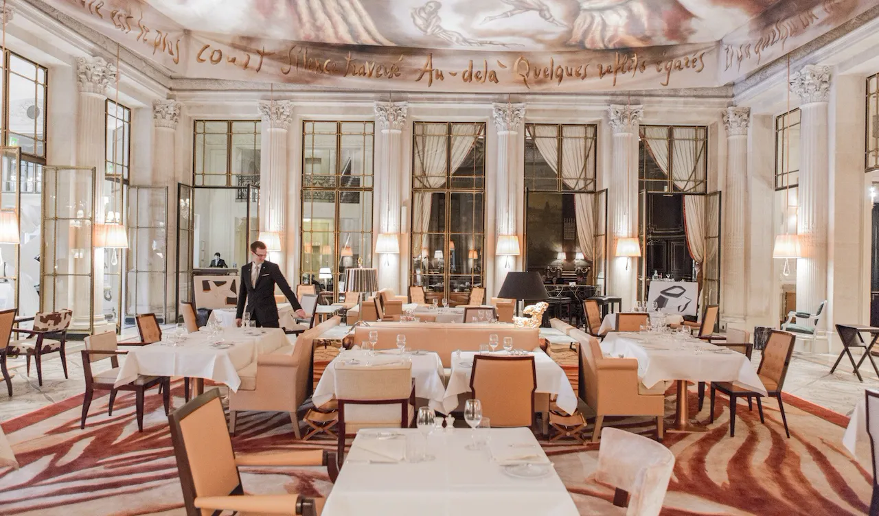 Overview shot of the restaurant room with a waiter in the room, at Restaurant le Dali at Le Meurice, Paris.