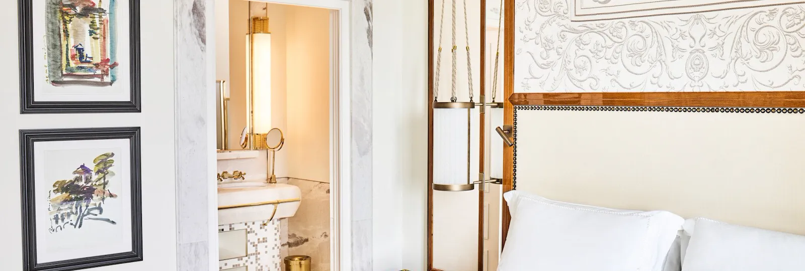 Bedroom of Classic suite with view with paintings on the wall and bathroom in the background at Hotel Eden, Rome