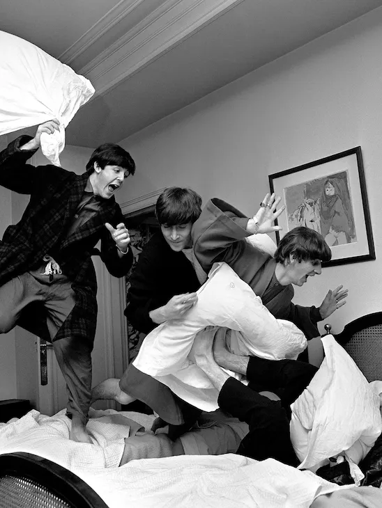 Photograph by Harry Benson of The Beatles jumping on bed at The Beverly Hills Hotel