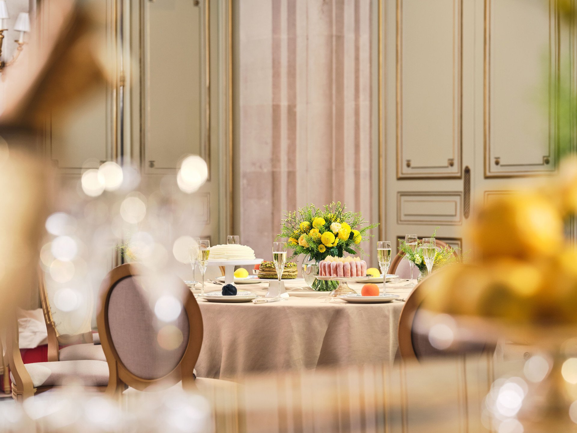 Grande vue de la table avec arrangement de fleurs, verres à champagne, gâteaux et fruits dans le Salon Tuileries, au Meurice, Paris - Dorchester Collection