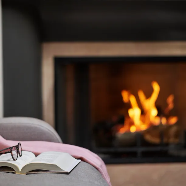 Book and glasses next to fireplace in Deluxe Bungalow Suite at The Beverly Hills Hotel, Los Angeles