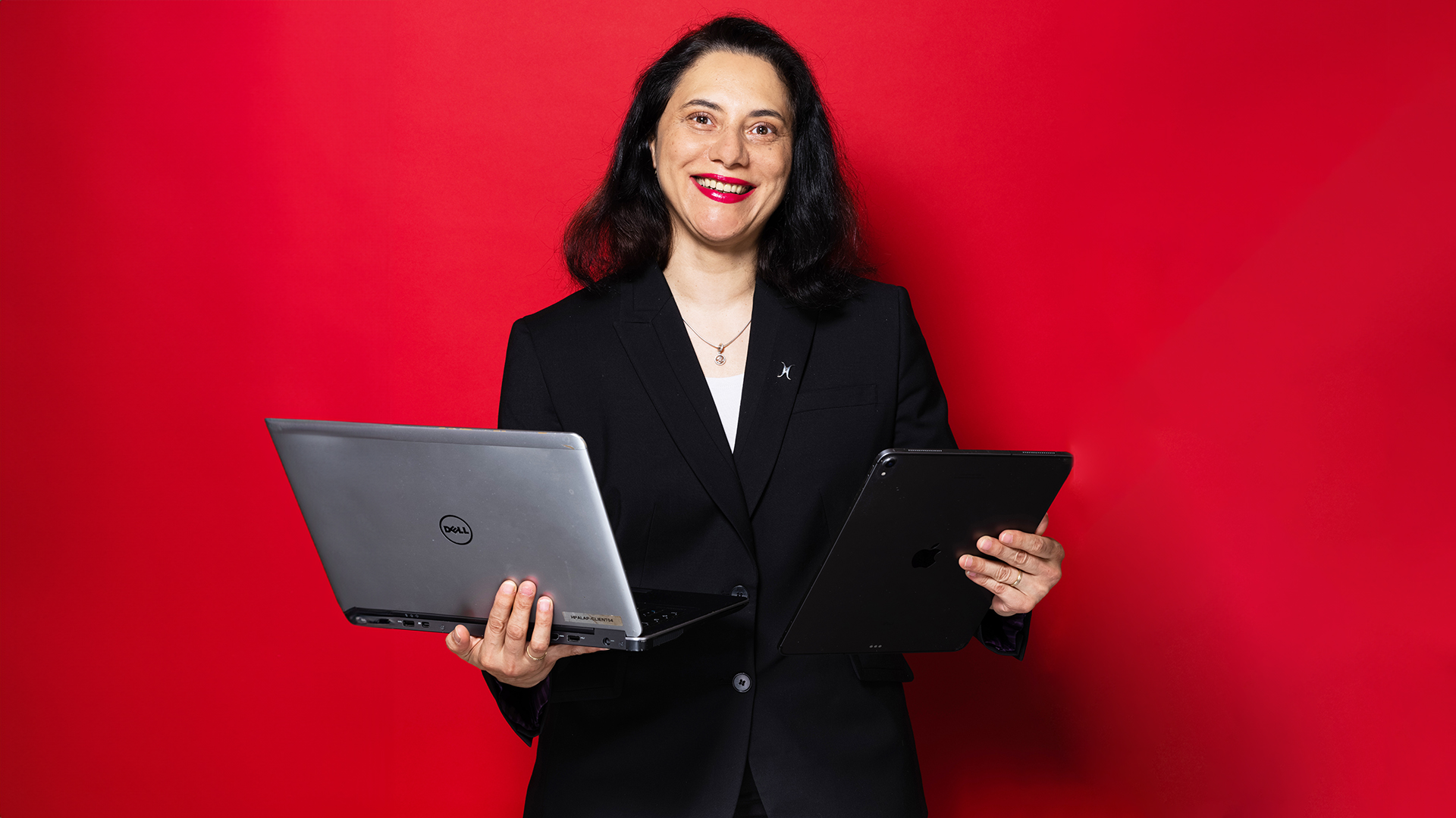 A woman holding laptop and tablet