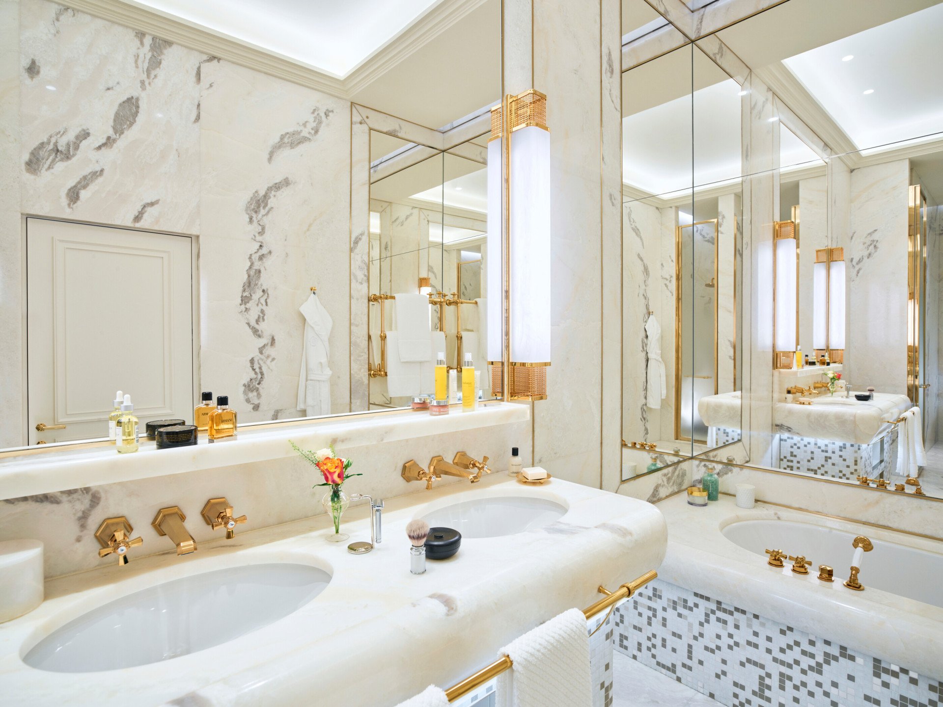 White marble bathroom of Dolce Vita Suite with double sinks, bathtub and mirrors with view of Rome at Hotel Eden