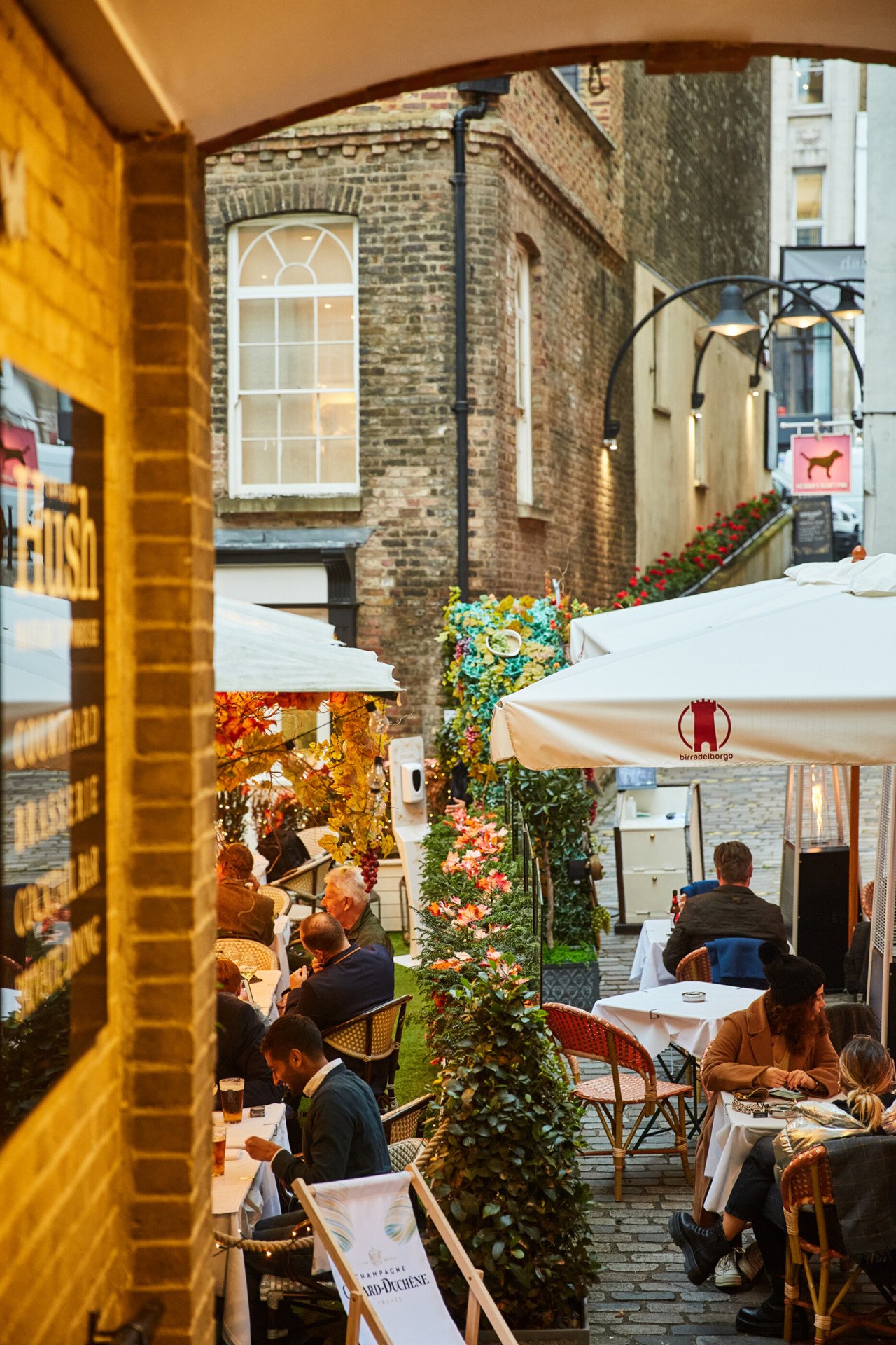 People sitting outside at restaurant in courtyard of Lancashire Court, Mayfair