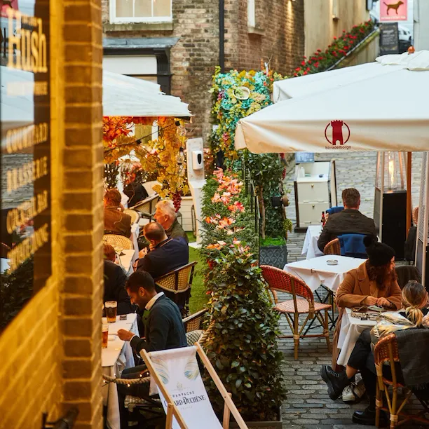 People sitting outside at restaurant in courtyard of Lancashire Court, Mayfair