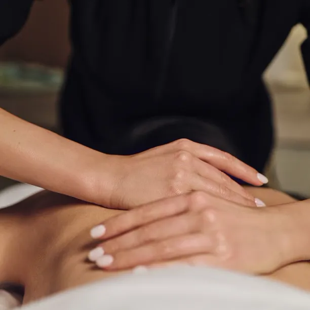 Terapista che massaggia la schiena di una persona sdraiata