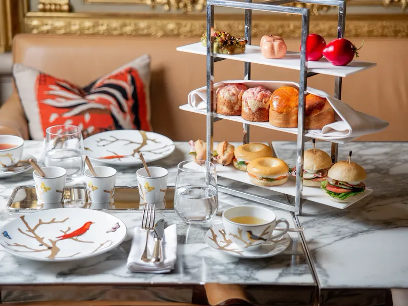 Landscape view of tea time food such as finger sandwhiches, pastries, sculpted fruits, tea and jam. At Restaurant le Dali at Le Meurice, Paris.
