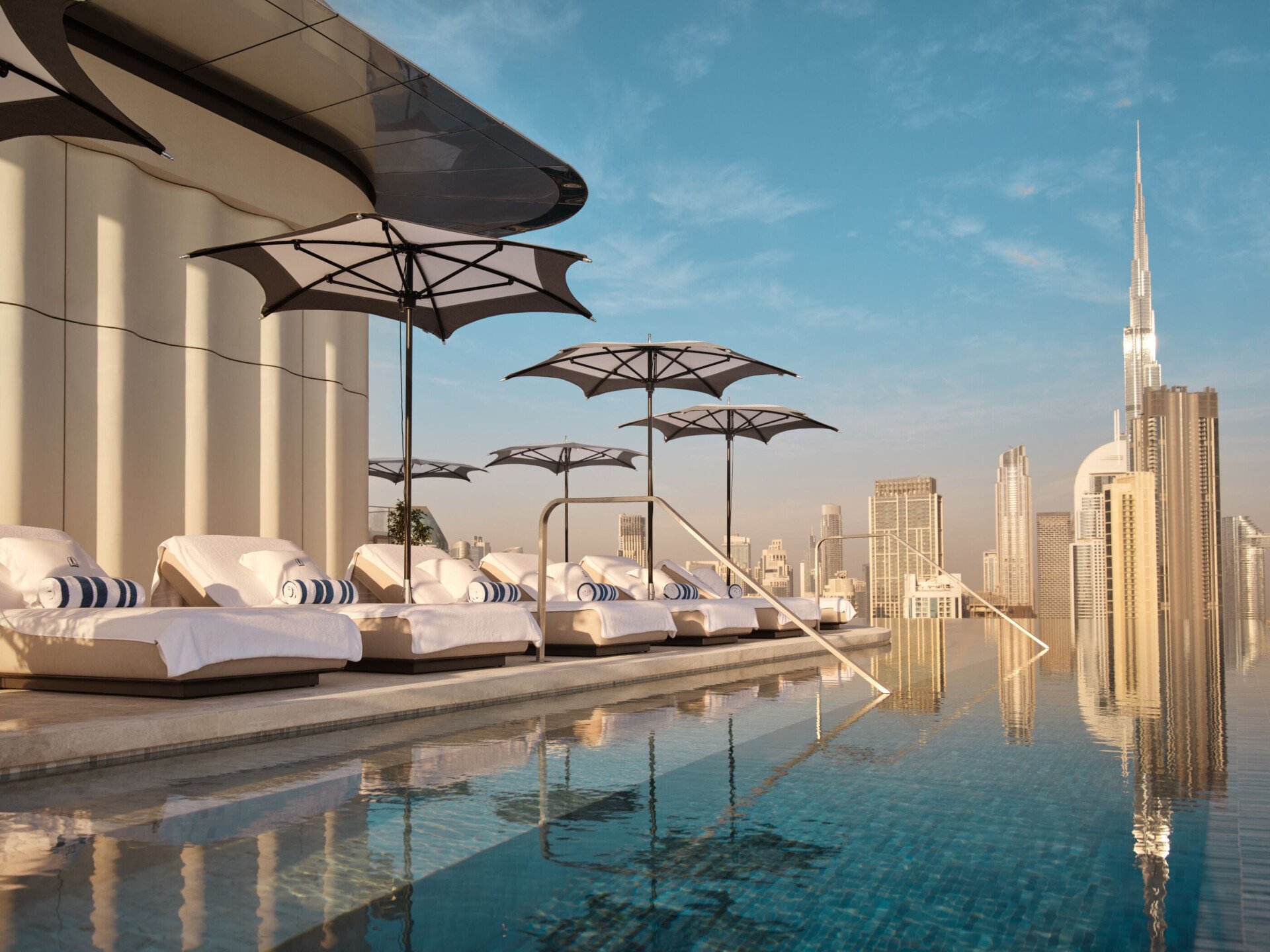 The Lana rooftop pool with sunlongers and view of Downtown Dubai