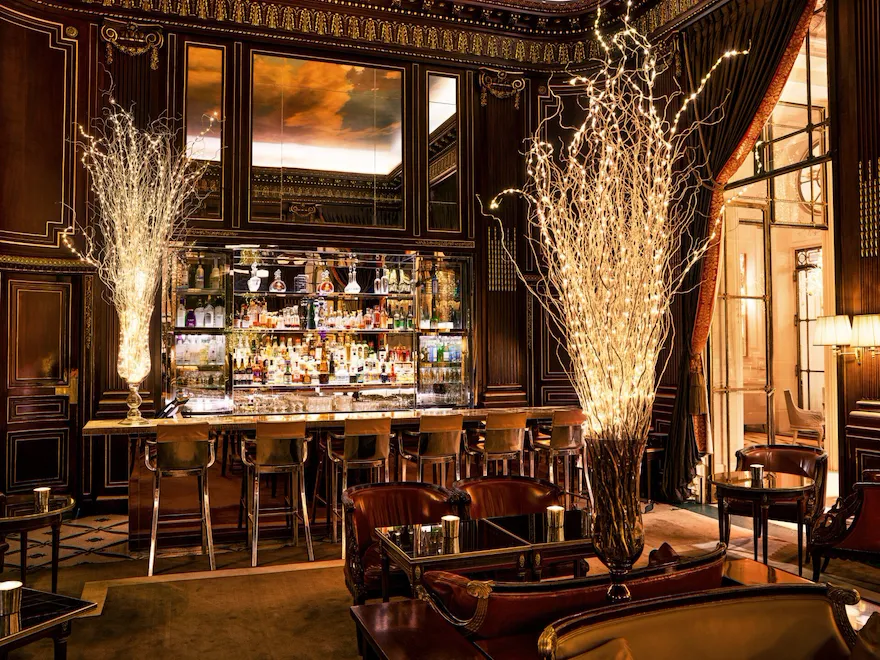 Vue panoramique sur le comptoir du Bar 228 pendant la période de Noël, avec des lumières en forme d’arbre de Noël, à La Meurice, Paris