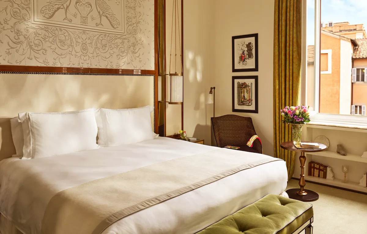 Camera da letto con finestra aperta e vista su Roma a Hotel Eden