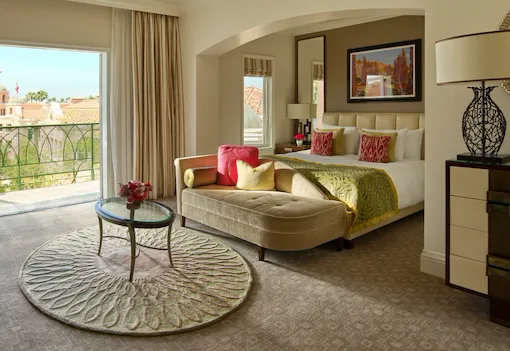 Deluxe guestroom with balcony, view of king bed and blue skies