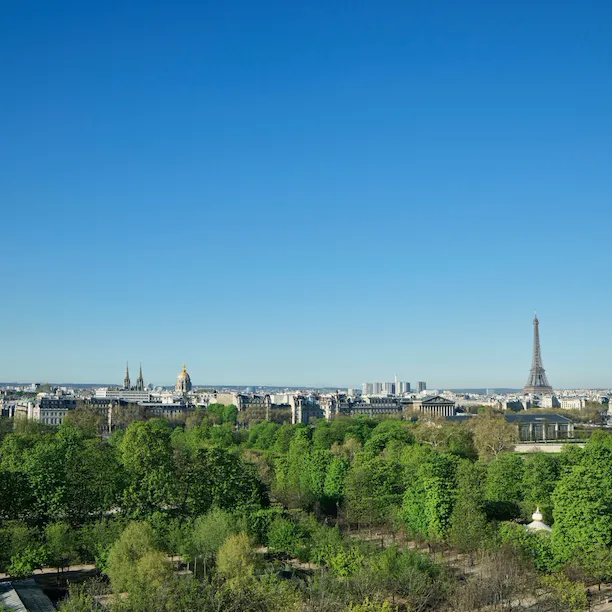 Vue depuis une chambre exécutive, avec les jardins des Tuileries à l’avant et la tour Eiffel à l’arrière. Au Meurice, à Paris.