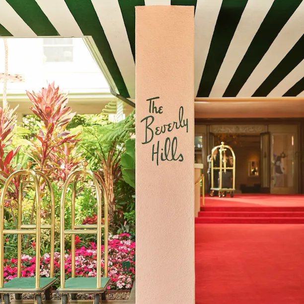 The Beverly Hills Hotel red carpet entrance with bellman carts in front.