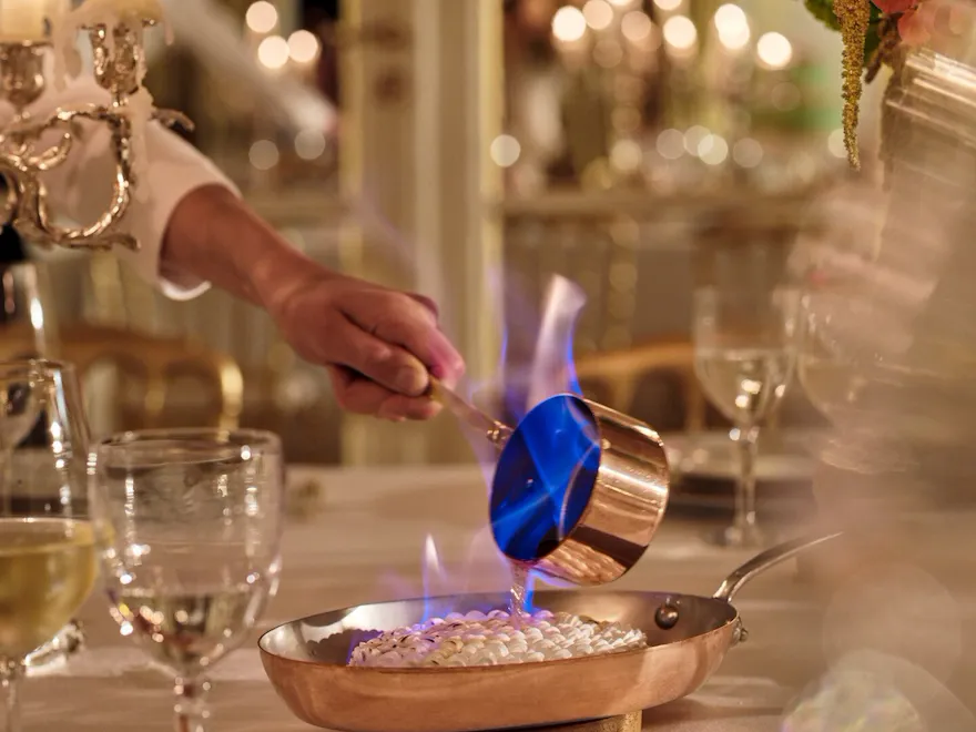 Dinner performance captured with gold and white tableware, pink and green flowers, green cakes, at Le Salon Organza, at Hôtel Plaza Athénée, Paris - Dorchester Collection.