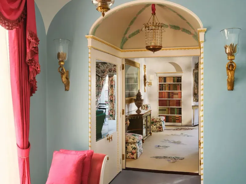 An elegant hallway leading to a living area with bookshelves
