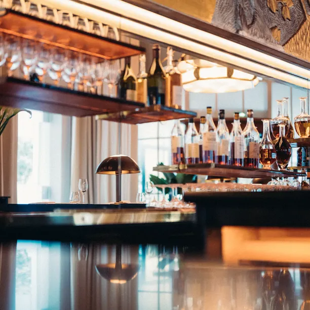 Le Relais Plaza bar wiith alcohol bottles and glasses, at Le Relais Plaza, at Hotel Plaza Athénée, Paris