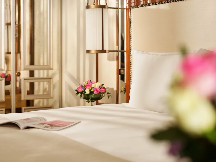 Dettaglio di una camera da letto con fiori bianchi e rosa sul comodino