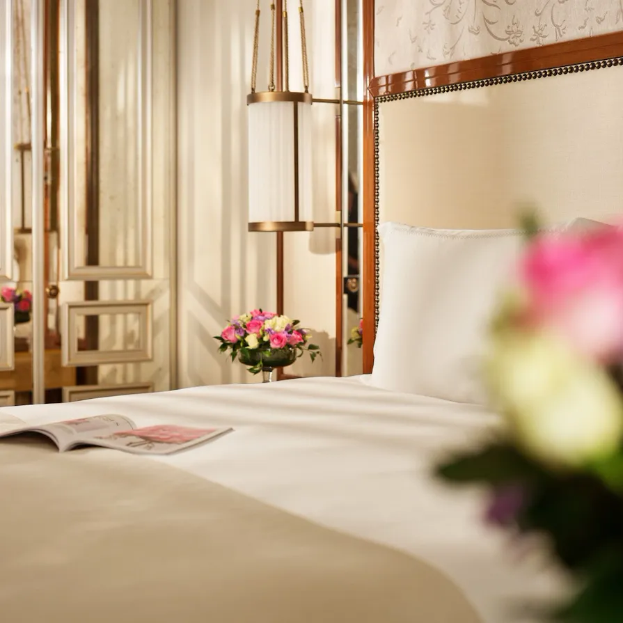 Dettaglio di una camera da letto con fiori bianchi e rosa sul comodino
