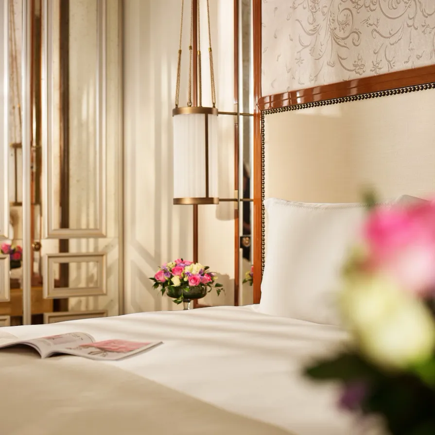 Close up on bedroom of prestige room, headboard with peacocks, night tables with flowers, at Hotel Eden, Rome