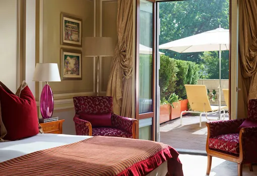 Bedroom with terrace doors open on a sunny day at Hotel Principe Di Savoia, Milan