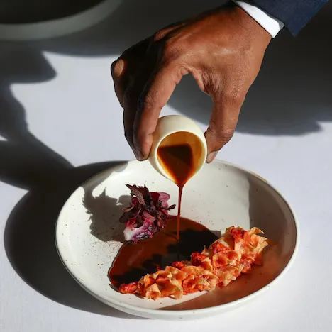 It is the picture of a white plate on a white table, containing a sophisticated presentation of crispy blue lobster, celery, bone marrow and lovage, at Le Meurice, Paris.