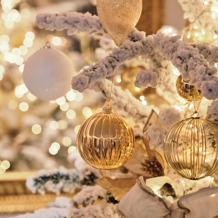 Zoom on Christmas tree ornaments with artificial snow on it and lights in a Prestige Suite, at Le Meurice, Paris