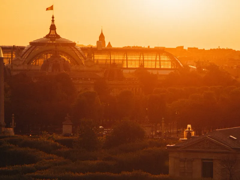 Photography of the Grand Palais from an elevated point with a sunset behind