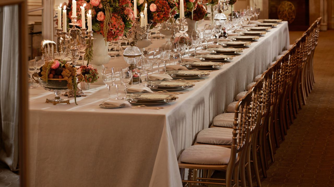 Dinner with gold and white tableware, pink and green flowers, crystal chandeliers at Le Salon Organza, at Hôtel Plaza Athénée, Paris - Dorchester Collection.