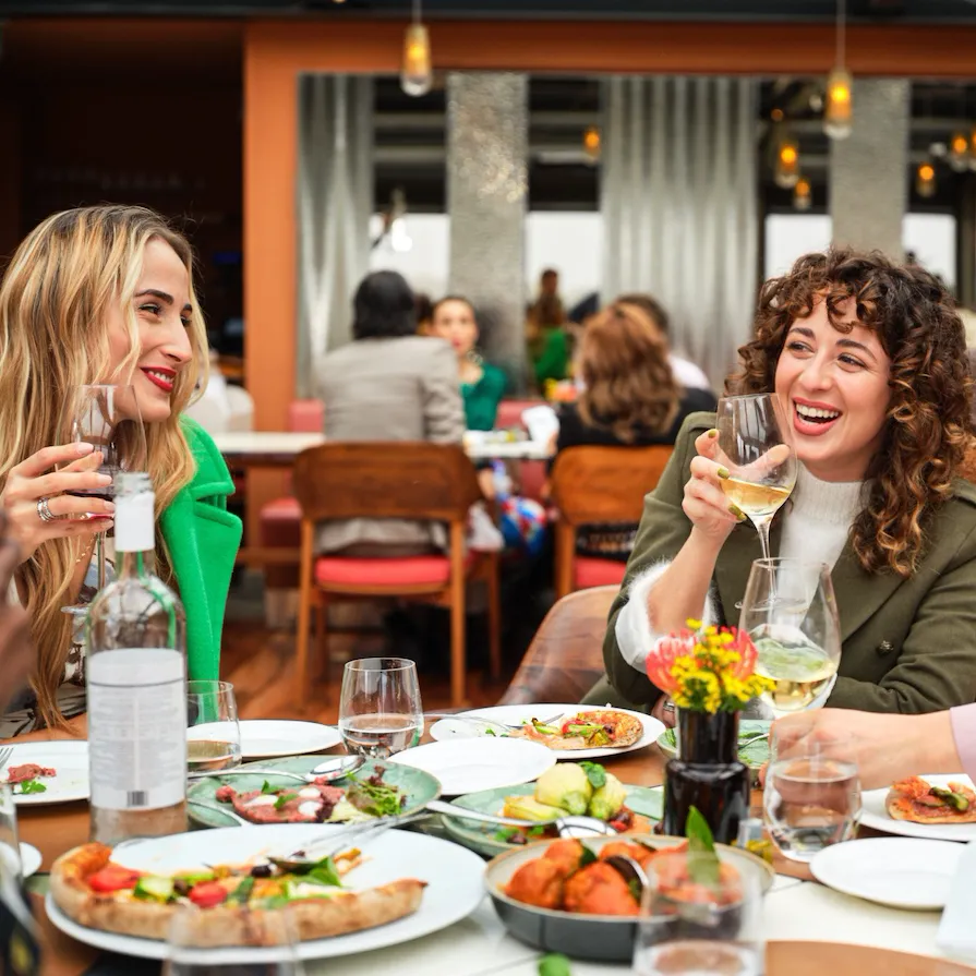 Giovani donne sorridenti che parlano e mangiano a Il Giardino Ristorante
