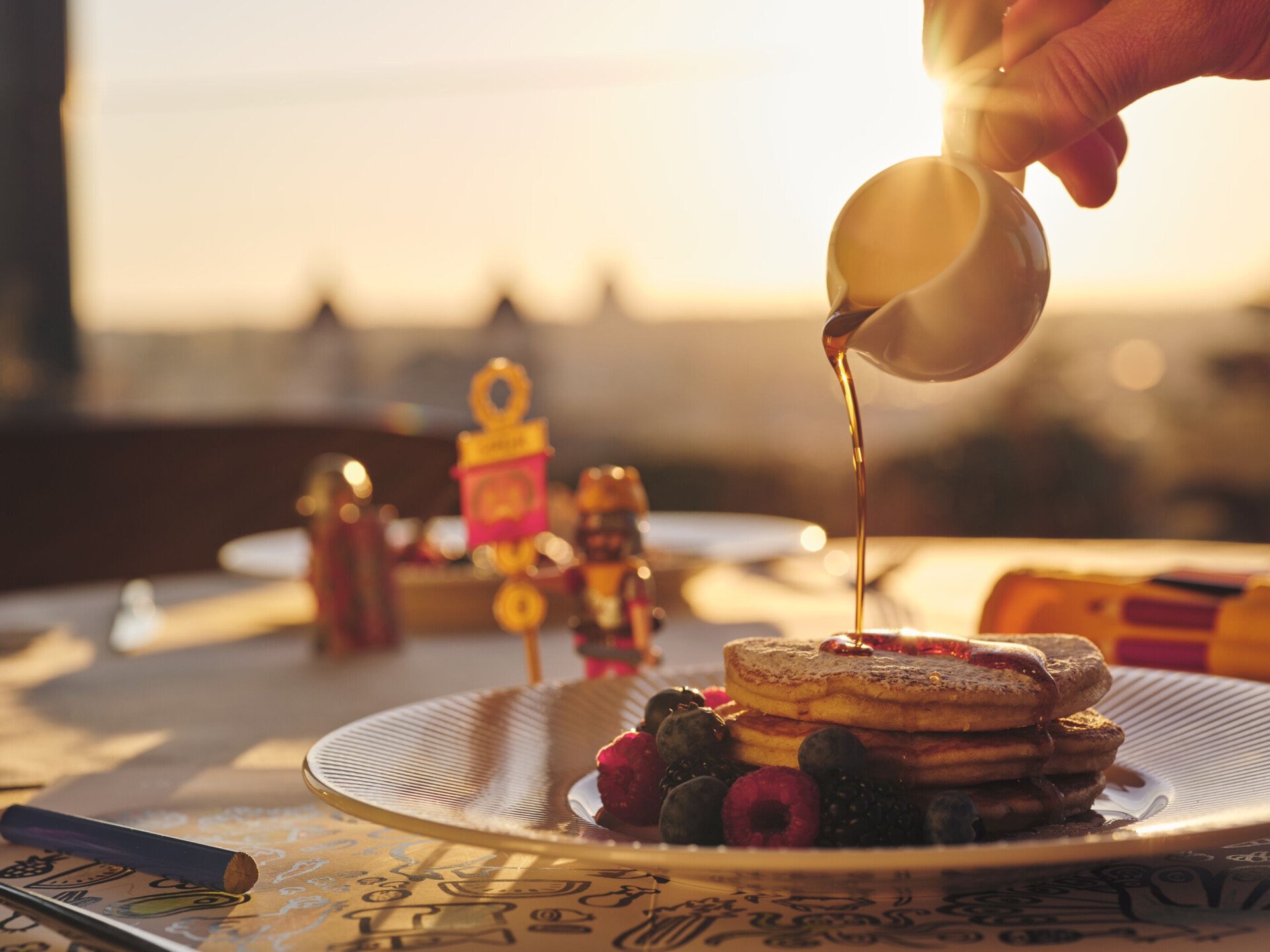 Kids breakfast made of pankakes, with syrup poured on top.
