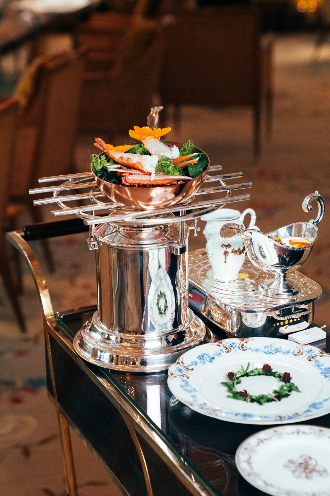Acht-person setting with decorative food and ornate tableware on a polished surface.