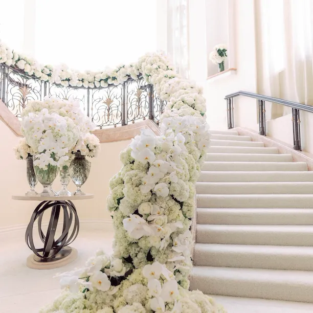 White florals cascading down grand staircase for wedding