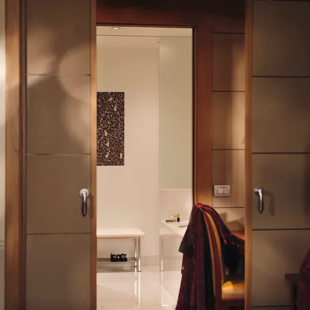 Vista del bagno dalla Camera da letto con una rivista in primo piano e una vestaglia rossa sullo sfondo