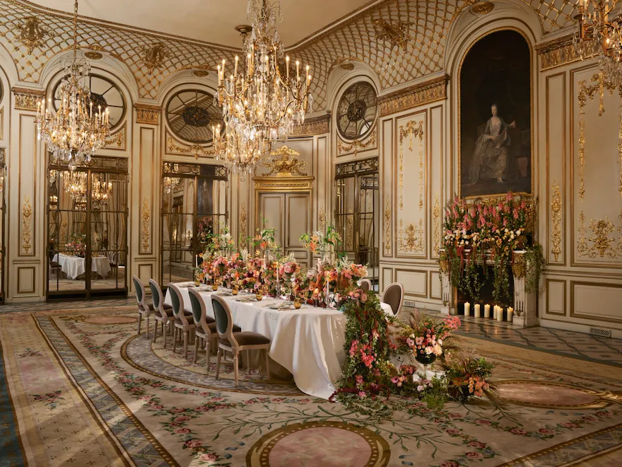 Jantar privado no Le Salon Pompadour com um longo arranjo floral e lareira ao fundo no Le Meurice, Paris - Dorchester Collection.