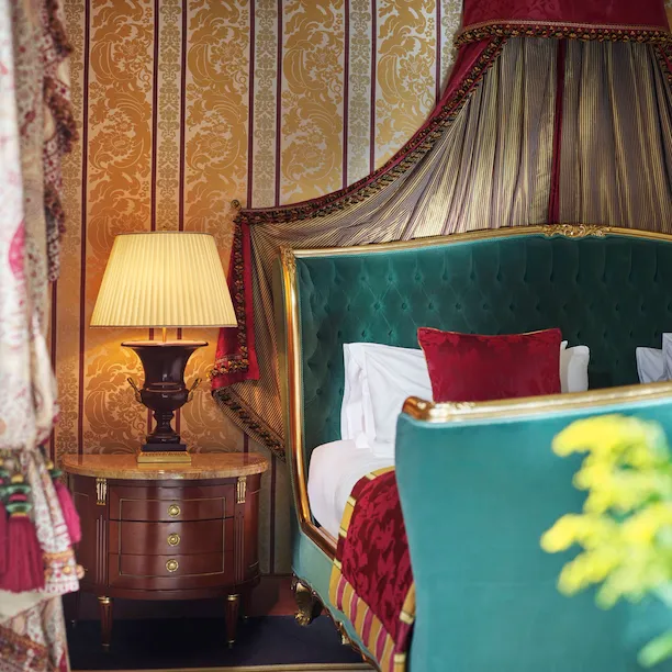 Camera da letto padronale della Suite Presidenziale con focus su parte del letto e il comodino