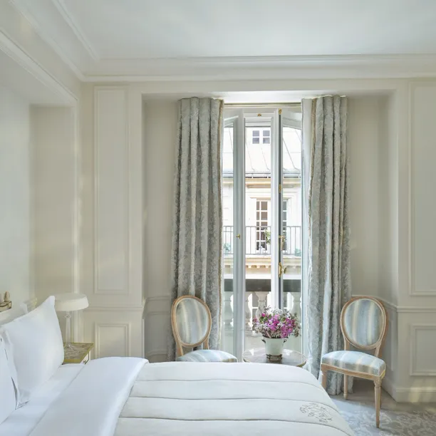 Vue de droite avec le lit à côté des fleurs devant la fenêtre, au Meurice, Paris
